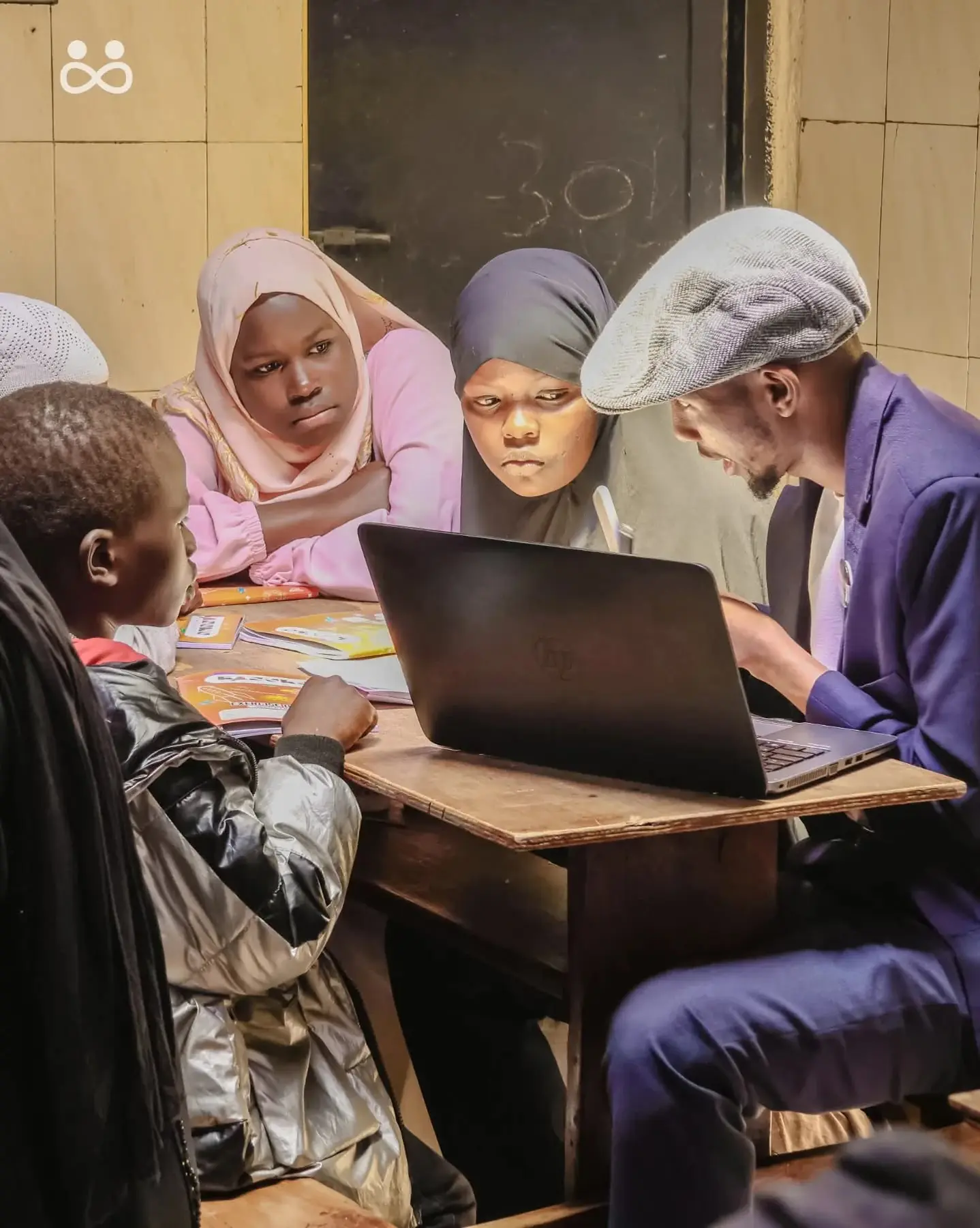 Three adults sitting around a laptop