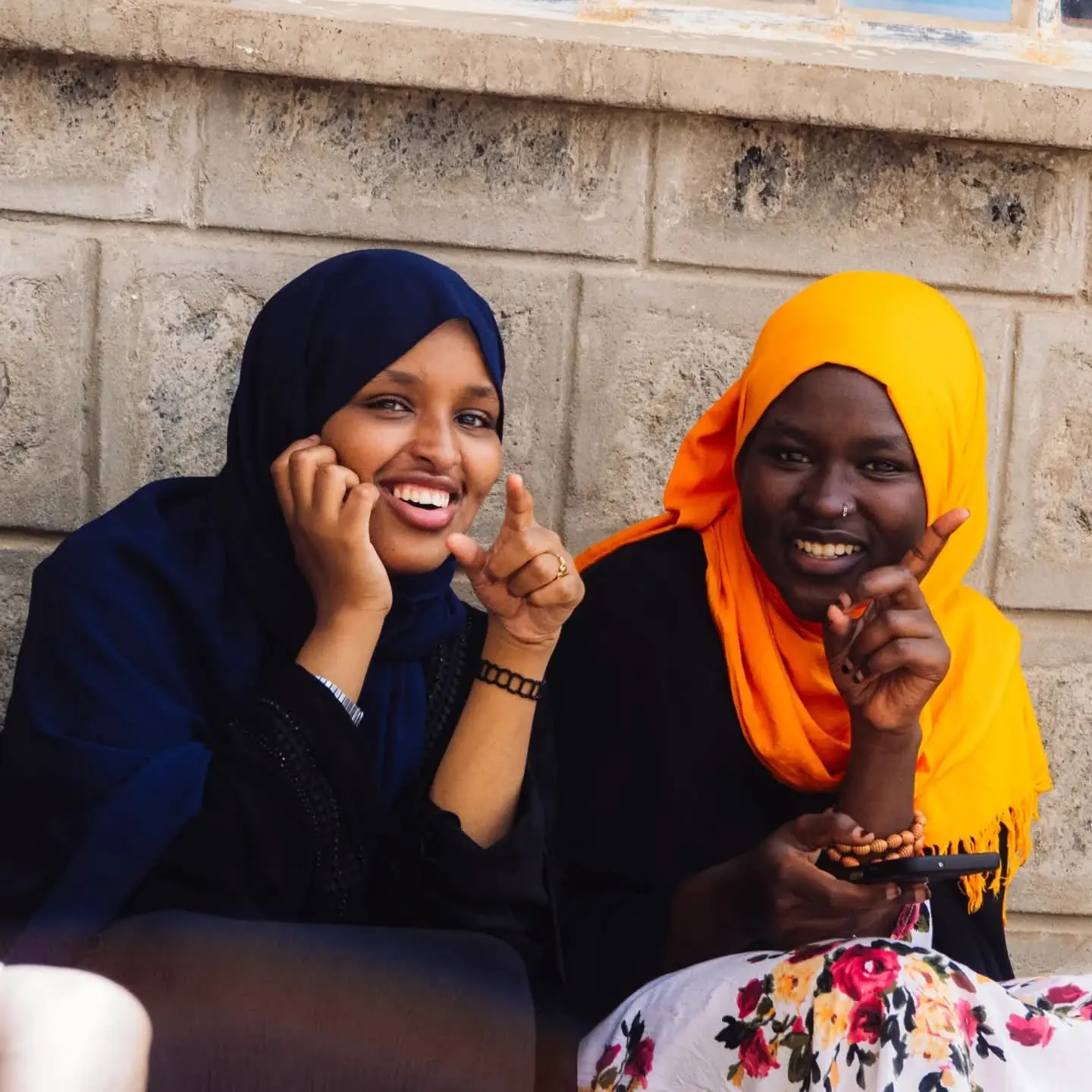 Two women smiling together at an indoor gathering