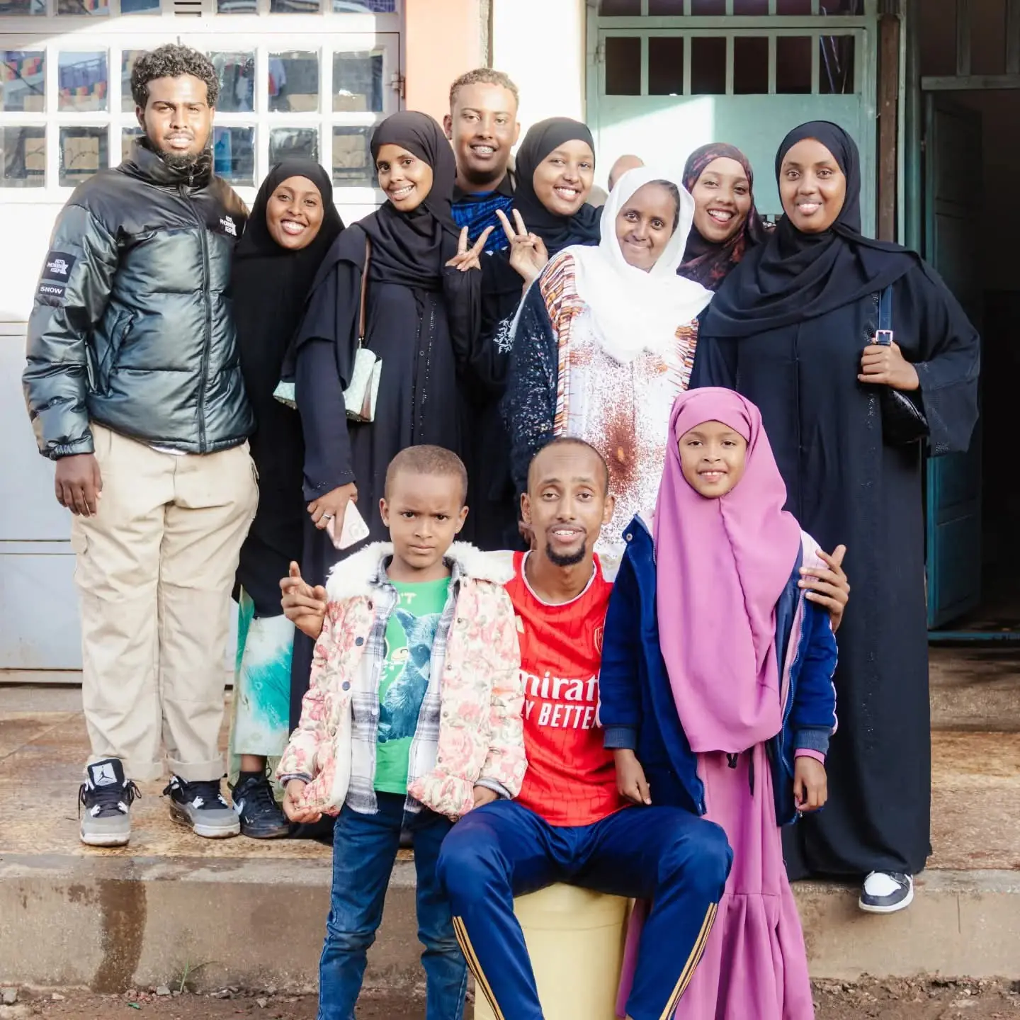 Children and adults posing together outside the home